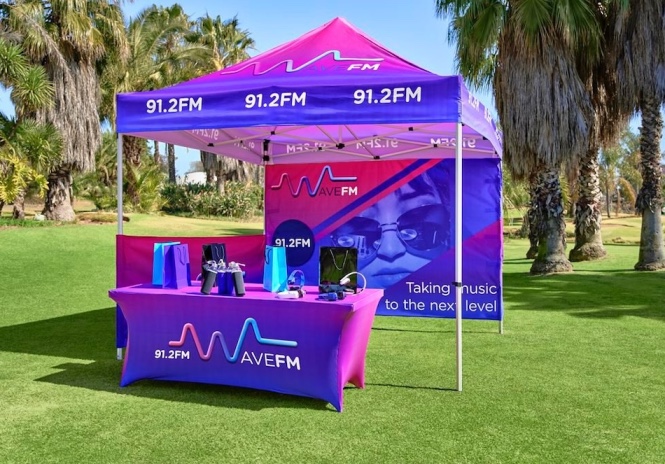 Branded outdoor display including branded gazebo, branded table cloths, branded stretch tablecloth, branded gazebo half wall and branded gazebo full wall.